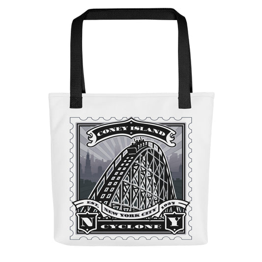 White canvas tote with Coney Island Cyclone rollercoaster vintage stamp illustration, black handles, wooden-rail and seaside detail.
